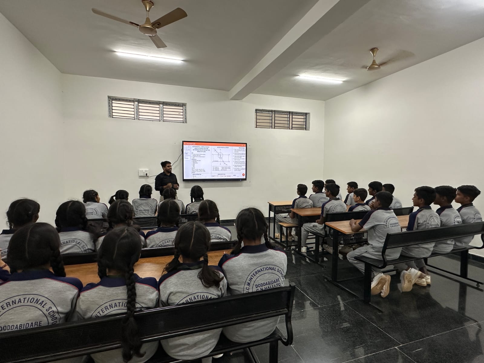 Teacher explaining a physics experiment on a smart board