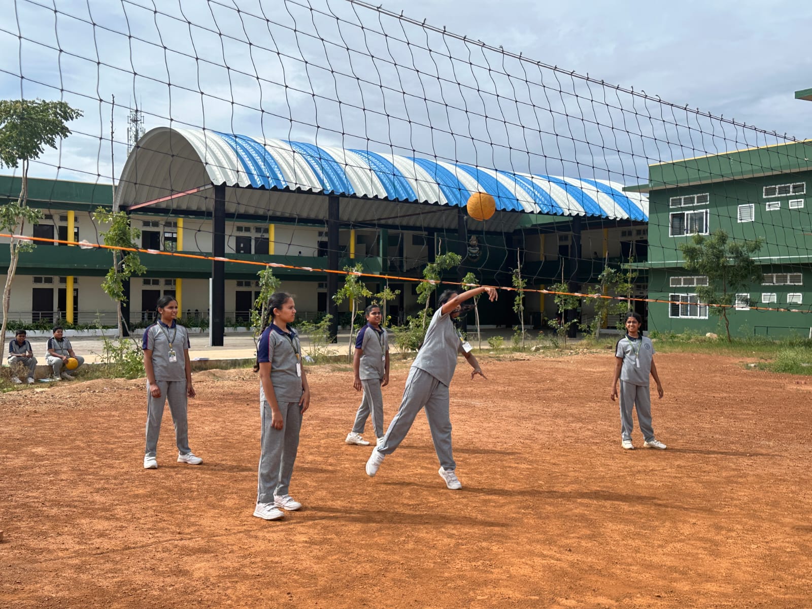 Students playing volleyball on the school ground